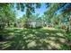 Spacious, grassy backyard, partially shaded by mature trees, offering a serene outdoor space at 12302- Pittsfield Ave, Tampa, FL 33624