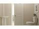 Bathroom featuring a pedestal sink and modern toilet with neutral-toned walls at 13527 White Gold Run, Parrish, FL 34219