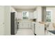 Stylish kitchen features white cabinets, stainless steel appliances and breakfast bar, brightened by a large window at 13527 White Gold Run, Parrish, FL 34219