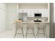 Bright kitchen with stainless steel appliances, white cabinetry, and breakfast bar seating for three at 13527 White Gold Run, Parrish, FL 34219