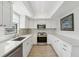 Modern kitchen featuring stainless steel appliances and ample white cabinetry at 13602 Frigate Ct # N201, Clearwater, FL 33762