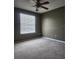 Clean bedroom features a ceiling fan and bright window with a view and neutral carpet at 14061 Notreville Way, Tampa, FL 33624