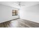 Neutral bedroom with wood-look flooring, window with view, and ceiling fan at 14255 Rosemary Ln # 8219, Largo, FL 33774