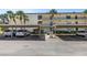 Exterior view of a condo building and parking lot, featuring covered parking and mature landscaping at 14255 Rosemary Ln # 8219, Largo, FL 33774