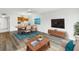 Open-concept living room and dining area with wood-look flooring and a mounted TV at 14255 Rosemary Ln # 8219, Largo, FL 33774