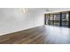 Bright, open living room with wood floors, chandelier, fan, and sliding glass doors to outdoor space at 14255 Rosemary Ln # 8219, Largo, FL 33774