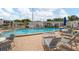 Community pool with lounge chairs and tables, surrounded by a brick patio and manicured grounds at 1655 S Highland Ave # C155, Largo, FL 33756
