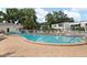 Community pool with lounge chairs and tables with umbrellas at 1655 S Highland Ave # C155, Largo, FL 33756