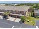 Aerial view of townhome featuring double garage, landscaping, and ample parking at 1725 Sommarie Way, Tarpon Springs, FL 34689
