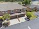 Aerial view of townhome featuring double garage, landscaping, and ample parking at 1725 Sommarie Way, Tarpon Springs, FL 34689