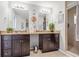 Bathroom featuring a double vanity, granite countertops, dark wood cabinetry and tile flooring and shower at 1725 Sommarie Way, Tarpon Springs, FL 34689