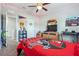 Cozy carpeted bedroom featuring ceiling fan, shelving unit, and a red Tampa Bay Buccaneers comforter at 1725 Sommarie Way, Tarpon Springs, FL 34689