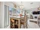 Bright dining area with a chandelier, seating for four, sliding glass doors, and a wine rack at 1725 Sommarie Way, Tarpon Springs, FL 34689