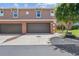 Attached two car garage on townhome with concrete drive and neutral exterior at 1725 Sommarie Way, Tarpon Springs, FL 34689