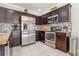 Well-equipped kitchen featuring stainless steel appliances, granite countertops, and dark wood cabinets at 1725 Sommarie Way, Tarpon Springs, FL 34689