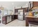 Well-equipped kitchen featuring stainless steel appliances, granite countertops, and dark wood cabinets at 1725 Sommarie Way, Tarpon Springs, FL 34689