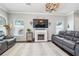 Bright living room with modern fireplace, elegant chandelier, and stylish gray leather seating at 1725 Sommarie Way, Tarpon Springs, FL 34689