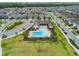 Community aerial view featuring a pool, clubhouse, and well-maintained landscaping surrounded by numerous homes at 17652 Ramble On Way, Land O Lakes, FL 34638