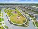 An aerial view of a Primary planned community with a central park, pool, playground, and well-maintained homes at 17652 Ramble On Way, Land O Lakes, FL 34638