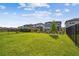 Spacious backyard with a well-maintained lawn, black fencing, and several modern homes at 17652 Ramble On Way, Land O Lakes, FL 34638