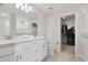 Clean bathroom with double vanity, white cabinetry, and a glimpse of a walk-in closet at 17652 Ramble On Way, Land O Lakes, FL 34638
