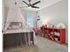 A bedroom with a princess theme, featuring a bed, a bookshelf, and a ceiling fan at 17652 Ramble On Way, Land O Lakes, FL 34638