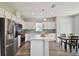 Modern kitchen featuring stainless steel appliances, white cabinets, a center island, and a dining area at 17652 Ramble On Way, Land O Lakes, FL 34638