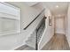Elegant staircase with decorative wrought iron spindles, a dark handrail, and light gray wood-look flooring at 17652 Ramble On Way, Land O Lakes, FL 34638
