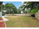 Spacious fenced backyard with a fire pit, grill, and partial view of a pool at 2204 Jennifer Ln, Valrico, FL 33594