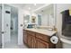Bathroom featuring a wood vanity cabinet, large mirror, and white tiled floor at 2204 Jennifer Ln, Valrico, FL 33594