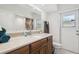 Bathroom with wood cabinets, tan countertop, and a large mirror above the sink at 2204 Jennifer Ln, Valrico, FL 33594