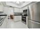 Bright kitchen featuring stainless steel appliances, white cabinets and tile flooring with dining area view at 2204 Jennifer Ln, Valrico, FL 33594