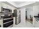 Galley kitchen with stainless steel appliances and granite countertops, adjacent to the dining room at 2204 Jennifer Ln, Valrico, FL 33594