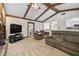 Living room with stone accents, wood beam ceiling, and seamless flow, perfect for entertaining at 2204 Jennifer Ln, Valrico, FL 33594