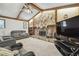 Cozy living room with a stone fireplace, wooden beam ceiling, and comfortable seating arrangements at 2204 Jennifer Ln, Valrico, FL 33594