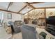 Inviting living room boasts a stone fireplace, wood beam ceilings, and cozy seating at 2204 Jennifer Ln, Valrico, FL 33594