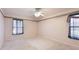 Clean, empty bedroom with carpet floors, neutral wallpaper, and windows that provide natural light at 2314 50Th E Dr, Bradenton, FL 34203