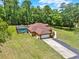 Back view of a home that features a screened-in pool and an attached two-car garage at 24498 Casey Rd, Brooksville, FL 34601