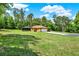 Home's backyard with a screened-in pool and expansive lawn at 24498 Casey Rd, Brooksville, FL 34601