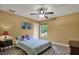 Sunny bedroom features bright wall art, plush pillows, and wood-look flooring at 24498 Casey Rd, Brooksville, FL 34601