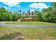 Long driveway leading to a beautiful stucco home with lush landscaping at 24498 Casey Rd, Brooksville, FL 34601