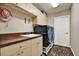 Functional laundry room featuring ample cabinet space, modern appliances, and patterned rug at 24498 Casey Rd, Brooksville, FL 34601
