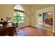 Bright home office features wood floors, a large window with a view, and an open doorway to the dining area at 24498 Casey Rd, Brooksville, FL 34601