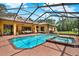 A bright blue swimming pool and hot tub is surrounded by a brick patio outside a home with patio furniture at 24498 Casey Rd, Brooksville, FL 34601