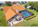 Aerial perspective of the home with a screened pool area, red tile roof, and well-maintained landscaping at 30314 Fairway Dr, Wesley Chapel, FL 33543