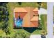 Aerial view of a private pool oasis with a unique kidney shape and a red tile roof highlighting the home's architecture at 30314 Fairway Dr, Wesley Chapel, FL 33543