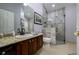 Bathroom with granite countertop, vanity, and a glass-enclosed tile shower at 30314 Fairway Dr, Wesley Chapel, FL 33543