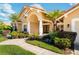Charming home exterior with a terracotta roof, a neatly landscaped yard, and a columned front porch at 30314 Fairway Dr, Wesley Chapel, FL 33543