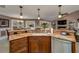 Kitchen island featuring granite countertops, wood cabinetry, stainless steel appliances, and barstool seating at 30314 Fairway Dr, Wesley Chapel, FL 33543