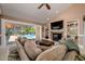 Cozy living room with a fireplace, built-in shelves, and a pool view at 30314 Fairway Dr, Wesley Chapel, FL 33543